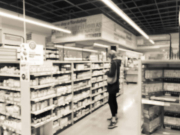 Gefilterde Toon onscherpe achtergrond gezonde vrouwelijke klant op zoek naar supplementen - Foto, afbeelding
