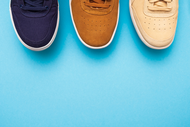 Three pair of sneakers on colored background - Photo, Image