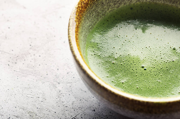 Top view of green tea matcha in a bowl on concrete surface. Close up shot - Valokuva, kuva