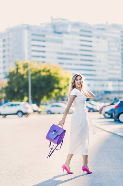 emotional spring summer portrait of Fashion stylish sexy of  young hipster blonde woman, elegant lady, bright colors dress, cool  girl. City view  urban lifestyle background. - Foto, Imagen