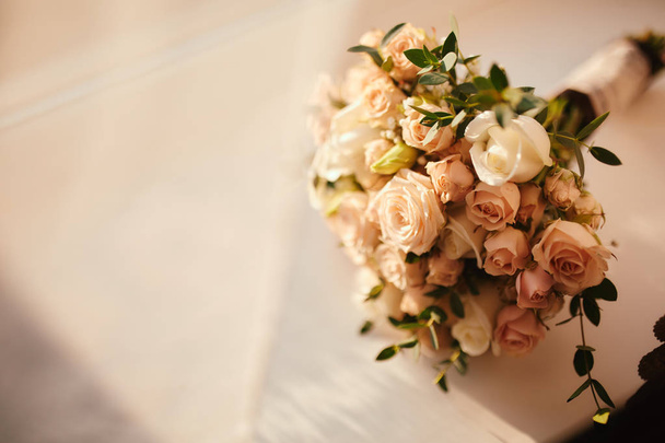 beautiful wedding bouquet. Stylish wedding bouquet bride of pink roses, white carnation and green flowers. Side view. Wedding decor. - 写真・画像