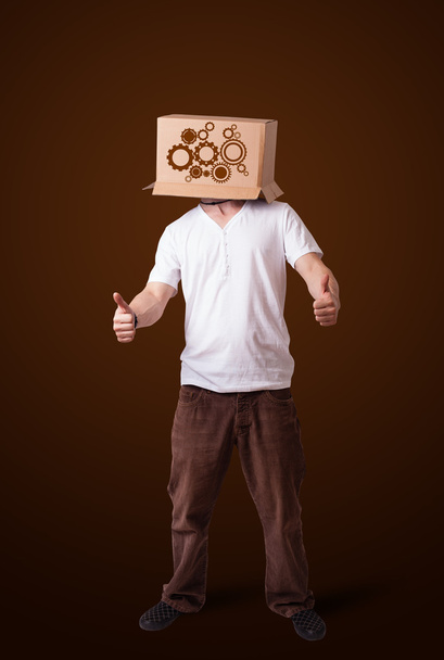 νεαρός άνδρας, χειρονομώ με ένα χαρτόκουτο στο κεφάλι του με το κέντρισμα w - Φωτογραφία, εικόνα