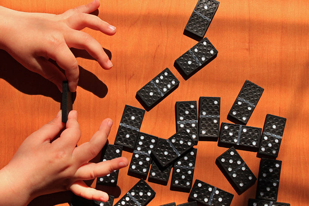 Ahşap bir arka plan üzerinde Domino oyunu oynamak için çocuklara öğretmek - Fotoğraf, Görsel