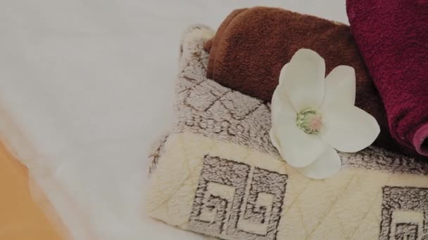 Salonky pro thajskou masáž s ručníky, polštáři a květinami v prázdné místnosti. - Záběry, video