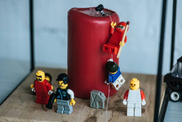 KYIV, UKRAINE - MARCH 15, 2019: close up view of lego characters climbing red candle with rope - Fotografie, Obrázek