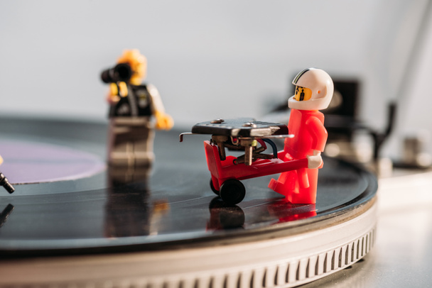 KYIV, UKRAINE - MARCH 15, 2019: selective focus of plastic lego figurine with toy trolley on vinyl record player - Foto, afbeelding