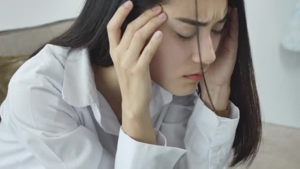 Ázsiai nő érzés stressz a munkából az irodában. Fáradt üzletasszony munkahelyen hivatalban gazdaságban a fejét a kezét úgy érzi, fejfájás. - Felvétel, videó