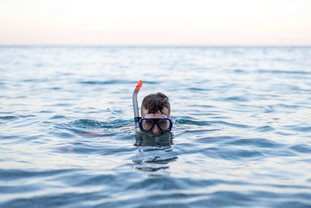 A fiatalember úszás egy búvár maszk. - Fotó, kép