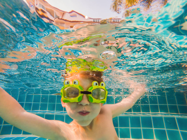 Υποβρύχια νεαρό αγόρι διασκέδαση στην πισίνα με γυαλιά. Καλοκαιρινές διακοπές διασκέδαση - Φωτογραφία, εικόνα