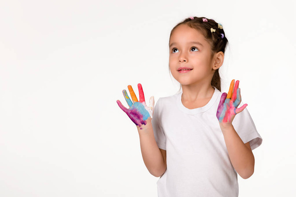 little child girl with hands painted in colorful paint - 写真・画像