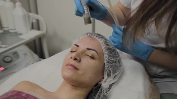 eine professionelle Kosmetikerin lässt eine Frau in einem Schönheitssalon das Gesicht staubsaugen. Kosmetologische Innovationen. - Filmmaterial, Video