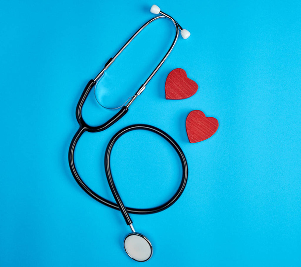 musta lääketieteellinen stetoskooppi ja puinen punainen sydän
 - Valokuva, kuva