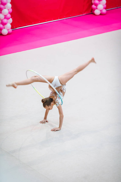 Маленькая гимнастка тренируется на ковре и готова к соревнованиям - Фото, изображение