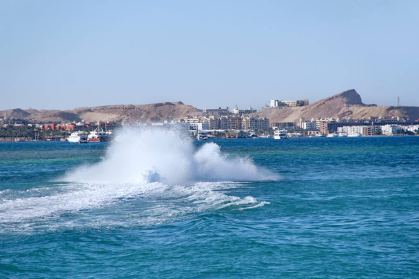 Быстрый лодка делает большие всплески на морской воде и прокатки туристов на Красном море
 - Фото, изображение