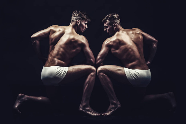 Fitness dieting and flexibility in acrobatics. Twins men with muscular body in pose. Circus gymnasts at pilates or yoga training. Friendship of men do gymnastic. Sport workout for bodybuilder - Fotoğraf, Görsel
