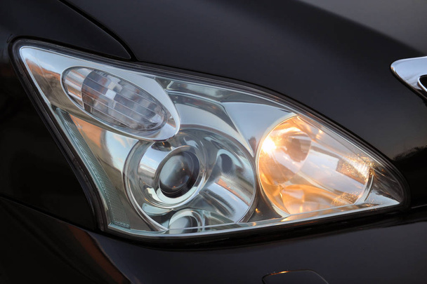 headlight of the main light of the black car, close-up. - Photo, image