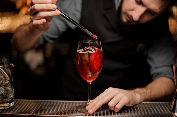 Male bartender pouring red cocktail in glass - Valokuva, kuva