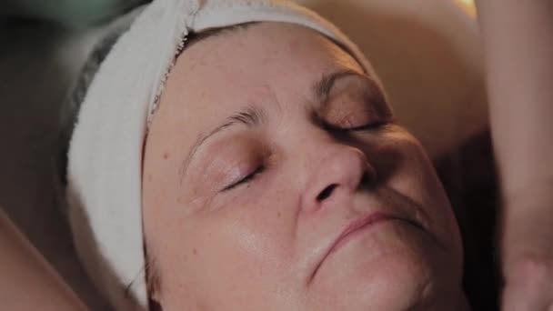 Una esteticista profesional prepara el rostro de una anciana para el procedimiento. Innovaciones cosmetológicas
 - Metraje, vídeo