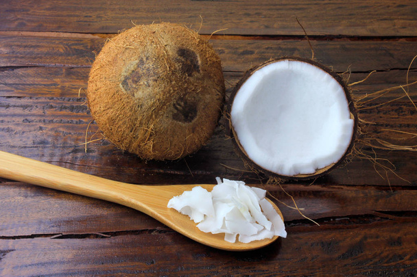 fresh coconut flakes and chips placed in bark isolated on rustic wooden background - 写真・画像