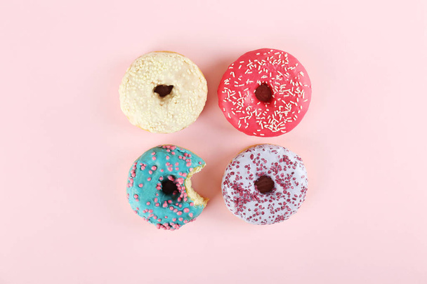 Minimal composition in vibrant colors with bright glaze donuts. - Zdjęcie, obraz