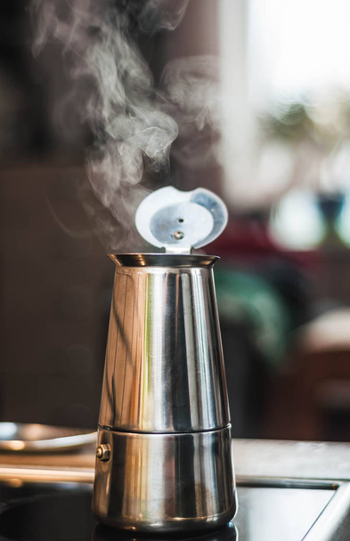 Ατμοσφαιρική ζεστή φωτογραφία του καφετιέρα σε μια σόμπα με βραστό - Φωτογραφία, εικόνα