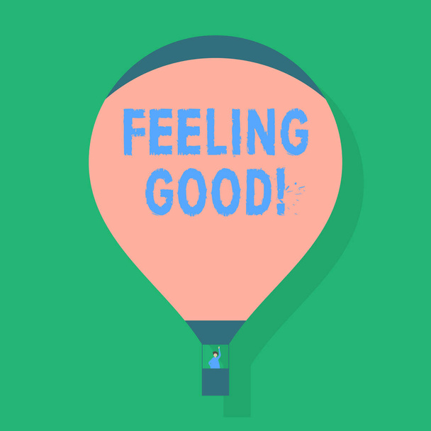 Psaní textu pocit dobré slovo. Obchodní koncept šťastný pozitivní pocity, které způsobují mít uspokojení prázdné růžové horkovzdušný balón plovoucí s jednou cestující mávat z Gondola. - Fotografie, Obrázek