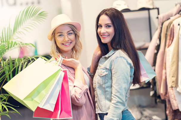 Girl friends shopping for clothes in store - Foto, Imagen
