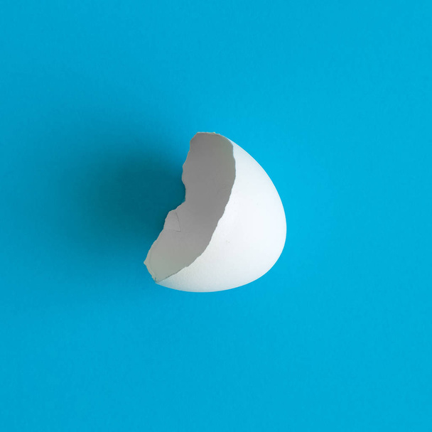 Close up of white eggshell abstract isolated on blue. - Foto, afbeelding