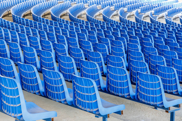 Řady modrých plastových židlí na kovové základně v řadách kolem kruhu v hale pro obchodní prezentace - Fotografie, Obrázek