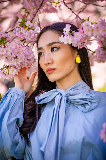 Mooie jonge Aziatische vrouw tijdens de bloei cherry blossoms tuin - Foto, afbeelding