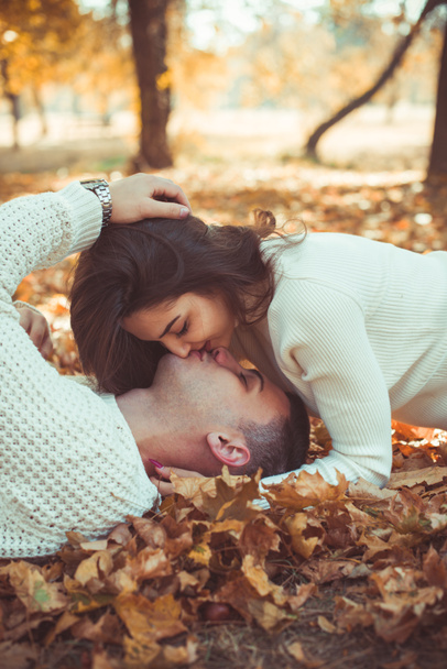 Великолепная пара с современной одеждой, целующаяся в парке
 - Фото, изображение