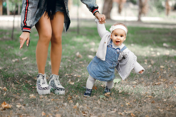 Matka trzyma rękę jej córki na dzień wiosny na świeżym powietrzu, Rodzina spacery w parku i cieszy się wzajemnie - Zdjęcie, obraz