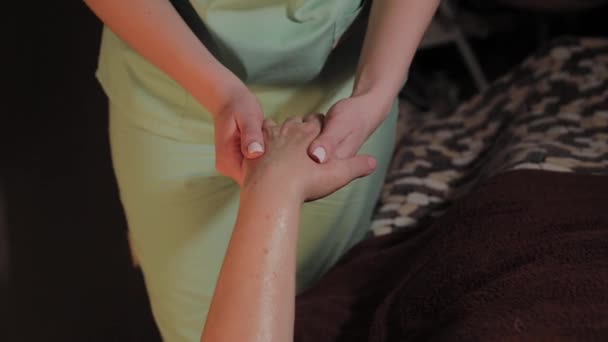 Professionele hand massage voor een oudere vrouw in een schoonheidssalon. - Video