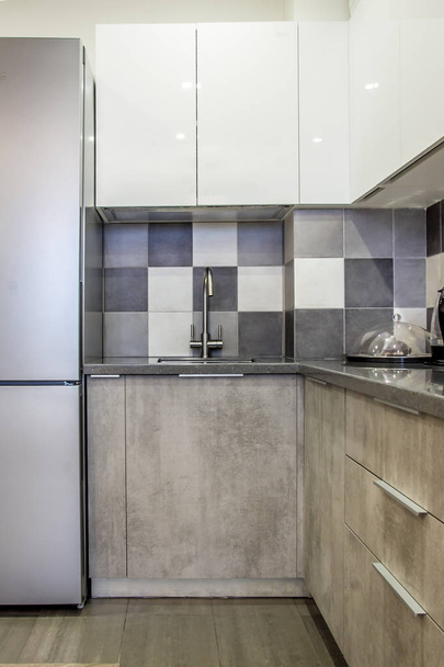 Современный интерьер кухни элементы декора с серым цементом и сегменты роскошной мебели пустой квартире с техникой и холодильником
 - Фото, изображение
