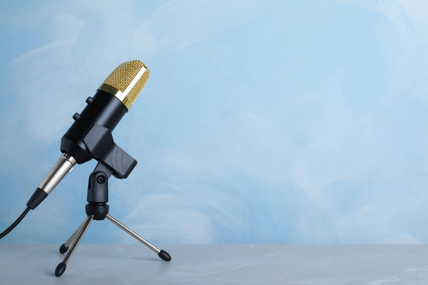 Microphone on table against color background. Space for text - Фото, зображення