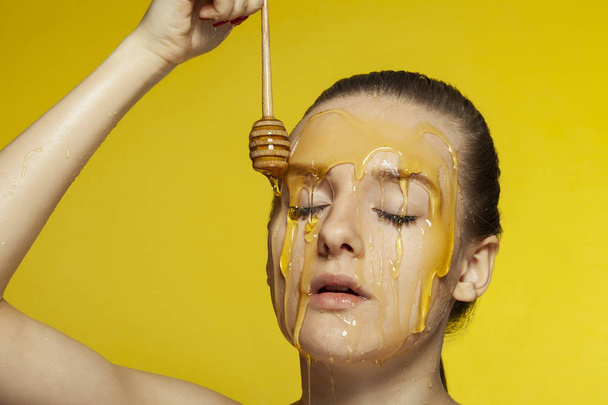 Woman with honey on her face. - Foto, imagen