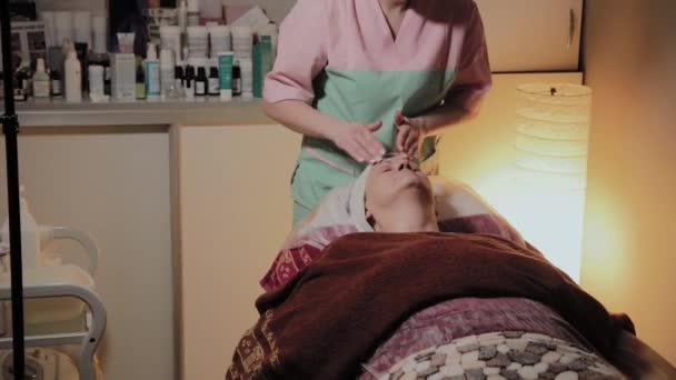 Una esteticista profesional prepara el rostro de una anciana para el procedimiento. Innovaciones cosmetológicas
 - Imágenes, Vídeo