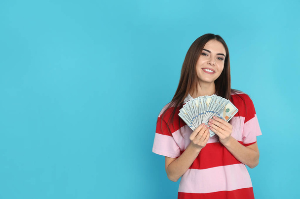 Young woman with money on color background. Space for text - Foto, imagen