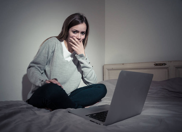 Scared and intimidated sad teenager bullied on line with laptop suffering cyberbullying and harassment. Child victim of bullying stalker social media, online challenges and dangers of internet. - Zdjęcie, obraz