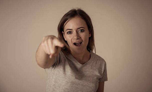 Portrait of angry and upset young teenager girl looking furious threatening and pointing at someone in People and human emotions, facial expressions, education, violence and bullying concept. - Фото, изображение