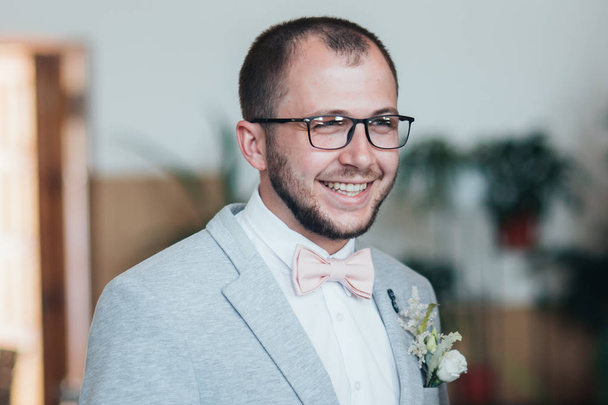 Wedding photo of emotions of a bearded groom with glasses in a g - Zdjęcie, obraz