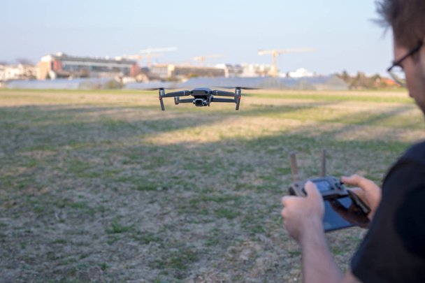 Joven dirigiendo un dron de alta tecnología afuera
 - Foto, Imagen