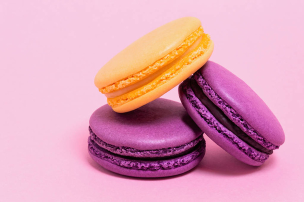 Three colored macaroons on a pink background. - 写真・画像