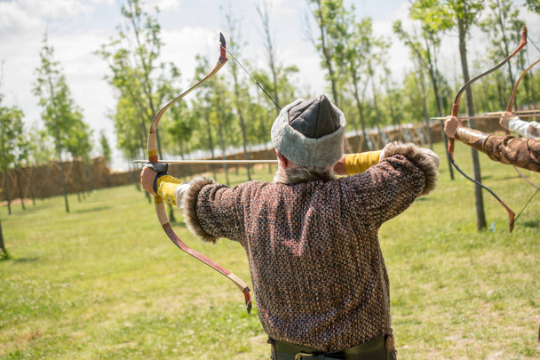 Archer w tradycyjne stroje, strzelającego z łuku - Zdjęcie, obraz