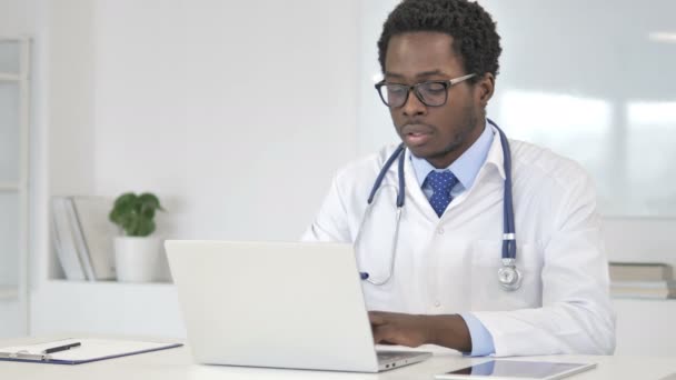 Médico africano trabajando en portátil
 - Imágenes, Vídeo