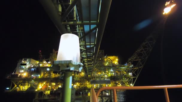 Olaj-és gázipar, offshore kilátás az olaj-és gázplatformra éjszakai környezetben a sötétség és a tenger mellett. - Felvétel, videó