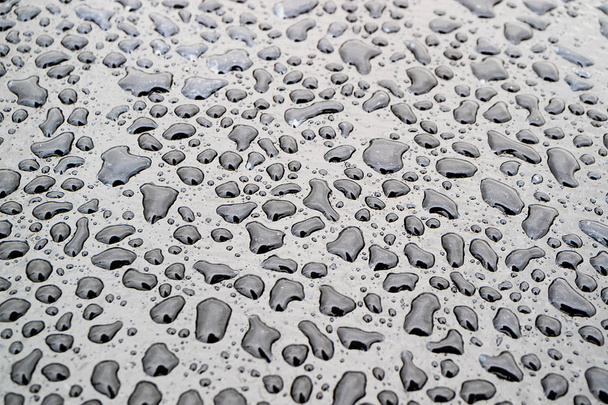 gouttes d'eau irrégulières à la surface sombre, gouttes de forme différente
 - Photo, image