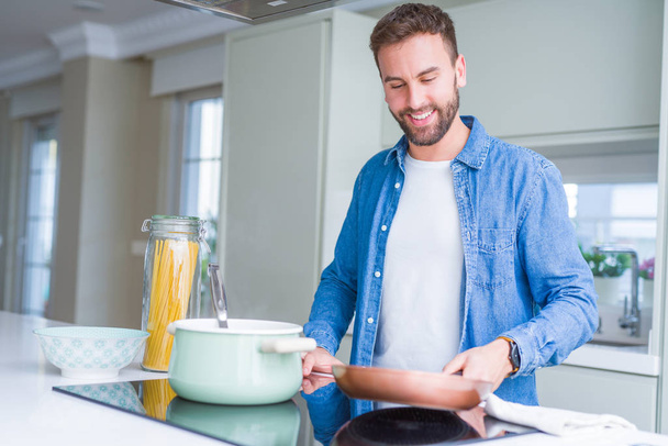 Handsome man cooking pasta at home - Foto, Imagem