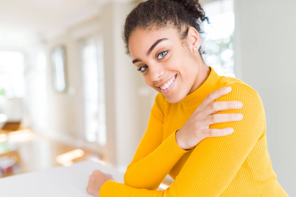 Beautiful young african american woman smiling friendly with crossed arms looking at the camera with big smile - 写真・画像