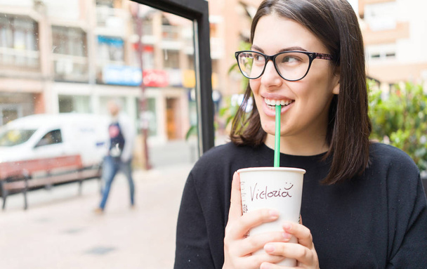 Belle jeune femme souriante joyeuse profitant d'une journée ensoleillée à boire une tasse de café à emporter
 - Photo, image